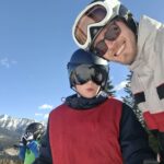 Gruppenszene im Winterferienlager: Kinder und pädagogische Betreuer*innen gemeinsam im Schnee mit Skiern und Schlitten – betreute Kinder- und Jugendreise im Wintercamp Wildfang e.V.