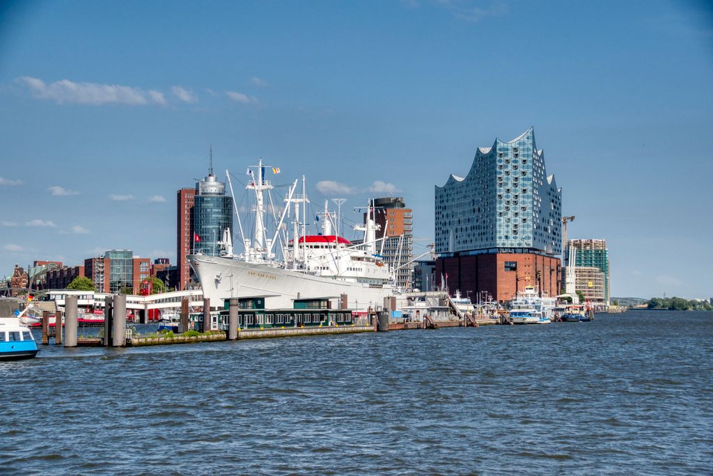A stunning view of the Elbphilharmonie and ships at the Hamburg harbor on a sunny day.